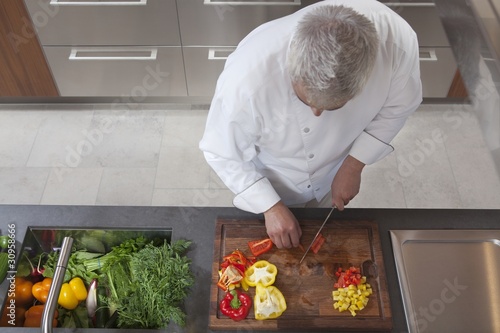Photo: Mid- adult chef dices peppers, overview Mid- adult chef dices peppers, overview