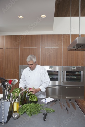 Photo: Mid- adult chef washing leaf vegetables Mid- adult chef washing leaf vegetables