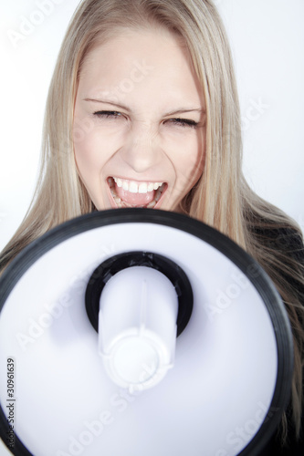 Photo: Blonde junge Frau mit Megafon fordert auf, hoch Blonde junge Frau mit Megafon fordert auf, hoch