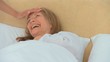A sick woman laughing in her bed