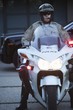 Patrol officer sits on motorcycle with hazrd lights lit