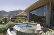 Exterior of a modern house with a small pool and mountains in the background