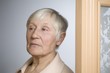 Elderly woman with short grey hair in doorway