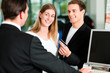 Couple signing sales contract at car dealer
