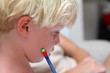 Foto: Young blonde boy doing homework with pencil Young blonde boy doing homework with pencil