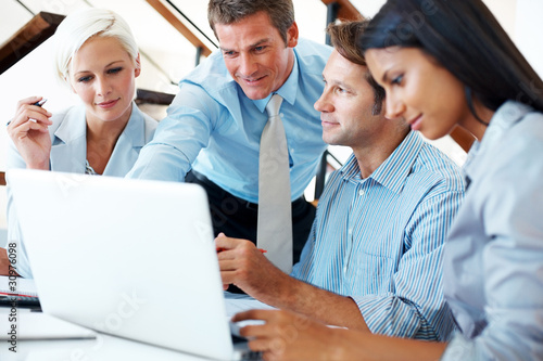 Photo: Successful business team working together on laptop Successful business team working together on laptop