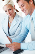 Businessman reading document with colleague at office
