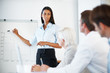 Young businesswoman giving presentation at office
