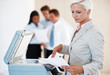 Young businesswoman working on xerox machine