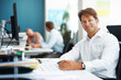 Handsome businessman sitting at desk using computer