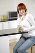 Young female enjoying a hot drink in her kitchen