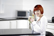 Young female enjoying a hot drink in her kitchen