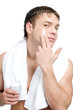 Man putting on cream lotion on face