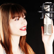 girl singing to the microphone in a studio girl singing to the microphone in a studio