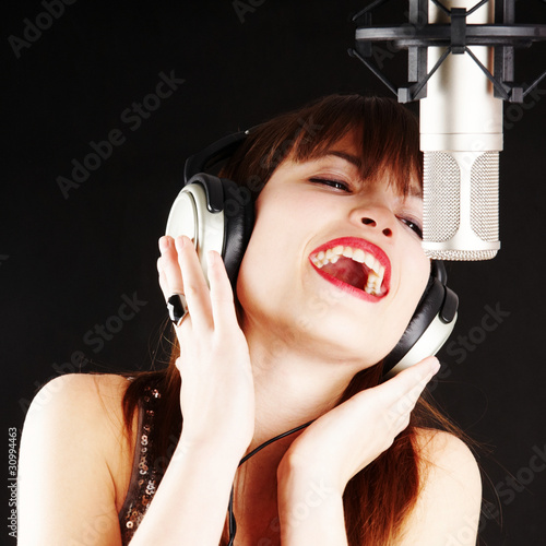 Photo: popstar woman singing to the microphone popstar woman singing to the microphone