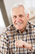 Senior Man With Glasses Relaxing In Chair At Home