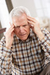 Senior Man Looking Stressed In Chair At Home
