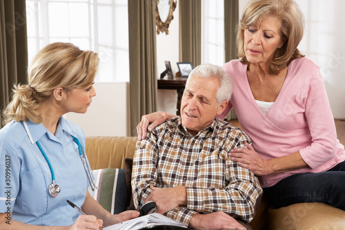 Photo: Senior Couple Talking To Health Visitor At Home Senior Couple Talking To Health Visitor At Home