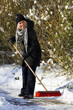 Woman sweeping pavement in winter