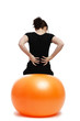 Foto: junge frau mit rückenschmerzen sitzt auf einem gymnastikball junge frau mit rückenschmerzen sitzt auf einem gymnastikball