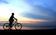 Silhouette of man riding bicycle with beautiful lake near by at Silhouette of man riding bicycle with beautiful lake near by at