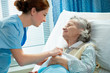 Nurse cares for a elderly woman lying in bed Nurse cares for a elderly woman lying in bed