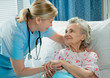 Nurse cares for a elderly woman lying in bed Nurse cares for a elderly woman lying in bed