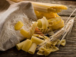 raw pasta with ears and flour on wood background