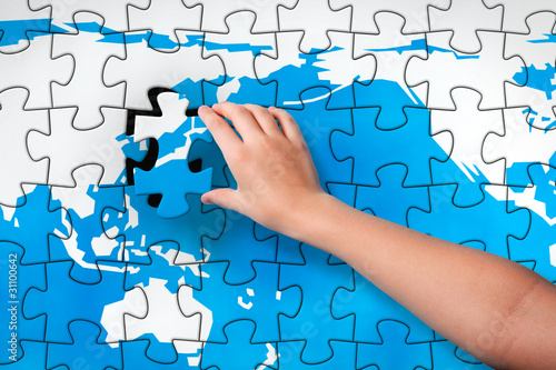 Illustration: Child's hand inserting piece of jigsaw puzzle into the map hole Child's hand inserting piece of jigsaw puzzle into the map hole