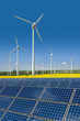 Windkrafträder und Solarmodule in einem Rapsfeld