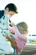 Boy helping girl onto rocking horse