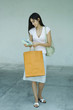 Woman holding shopping bag and gift, full length portrait