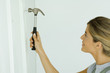 Woman hammering nail, close-up