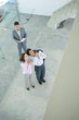 Photo: Real estate agent showing unfinished house to enthusiastic young couple, high angle view Real estate agent showing unfinished house to enthusiastic young couple, high angle view