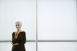 Senior woman standing with hand out, smiling at camera