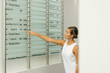 Photo: Woman looking at building directory, pointing at number Woman looking at building directory, pointing at number