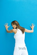 Photo: Woman in pants with the word truth" on backside, standing with hands against wall, looking over shoulder at camera" Woman in pants with the word truth" on backside, standing with hands against wall, looking over shoulder at camera"