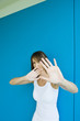 Woman holding hands in front of face, looking at camera