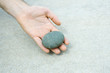 Man holding pebble in hand, cropped view