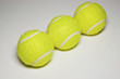 Three tennis balls in a row, close-up