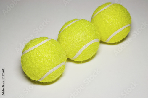 Photo: Three tennis balls in a row, close-up Three tennis balls in a row, close-up
