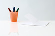 Notebook and pens inside cup