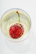 Cherry and bubbles in champagne glass, high angle view