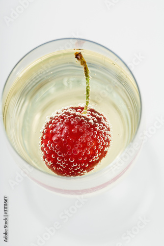 Photo: Cherry and bubbles in champagne glass, high angle view Cherry and bubbles in champagne glass, high angle view