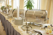 Table with dishware and shiny marmites