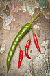 Red and green peppers on a old cracked wooden background