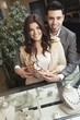 A couple in a jewellery shop holding a luxurious, exclusive ring