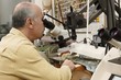 Photo: Jeweller working on gem stone to cut and polish and make exclusive jewellery designs Jeweller working on gem stone to cut and polish and make exclusive jewellery designs
