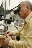 Photo: Jeweller working on gem stone to cut and polish and make exclusive jewellery designs Jeweller working on gem stone to cut and polish and make exclusive jewellery designs
