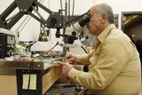 Photo: Jeweller working on gem stone to cut and polish and make exclusive jewellery designs Jeweller working on gem stone to cut and polish and make exclusive jewellery designs